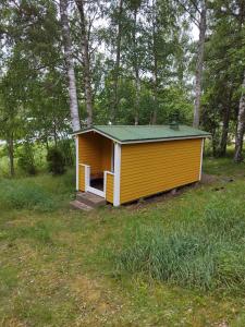 uma pequena casa amarela no meio de um campo em Mysig Stuga På Houtskär em Houtskari