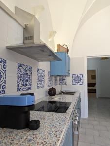 a kitchen with blue and white tiles on the wall at Masseria Petrore Grande di Polimeno Alessandra in Cutrofiano