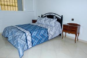 ein Schlafzimmer mit einem Bett mit einem Nachttisch und einem 6-dx-dx-Bett in der Unterkunft Charming apartment with a small garden in Tangier