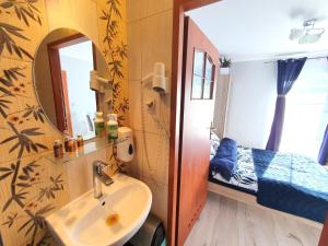 a bathroom with a sink and a mirror and a bed at WILLA AVATAR Mielno - 50 m od plaży, centrum, główny deptak in Mielno