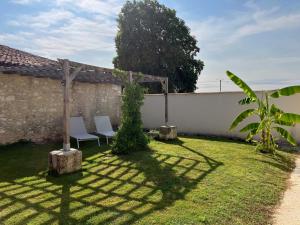 un giardino con due sedie e una recinzione di Le Chai des Annereaux a Saint-Sulpice-de-Cognac