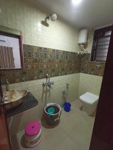 a bathroom with a toilet and a sink and a toilet bowl at Green Valley Resort in Thāl