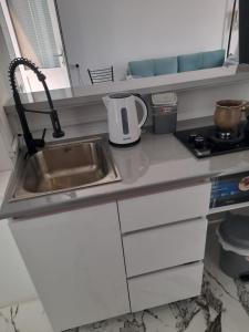 a kitchen counter with a sink and a stove at Gaukmebulia in Siskala