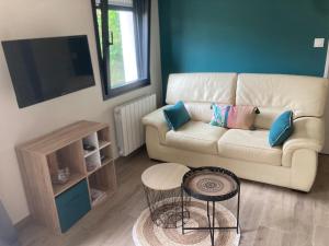 a living room with a couch and a table at Petite maison ensoleillée à 10 minutes du port de Vannes in Vannes