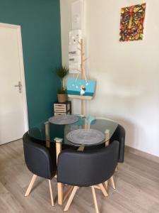 a dining room table and chairs with a glass table at Petite maison ensoleillée à 10 minutes du port de Vannes in Vannes