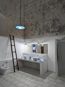 Un baño con dos lavabos y una escalera. en Masseria Petrore Grande di Polimeno Alessandra, en Cutrofiano