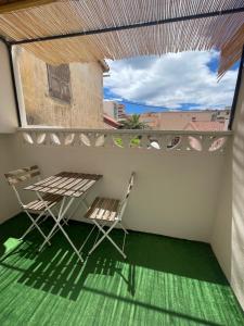 a balcony with two chairs and a table and a window at Ezz'Hotel Canet in Canet-en-Roussillon +48 photos