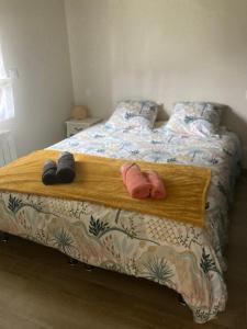 ein Bett mit zwei Paar Hausschuhen drauf in der Unterkunft Petite maison ensoleillée à 10 minutes du port de Vannes in Vannes