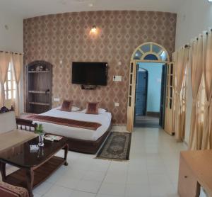 Shiva Ganges View Guest House في فاراناسي: غرفة فندق بسرير وتلفزيون