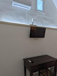 a room with a table and a tv and a window at Masseria Petrore Grande di Polimeno Alessandra in Cutrofiano