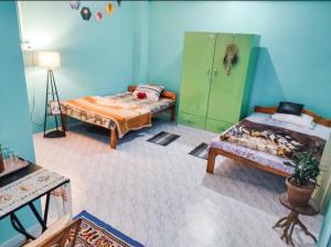 Nimchung bhutia residence في Temi: غرفة بسريرين وكابينة خضراء
