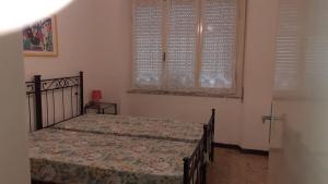 a bedroom with a bed and two windows at Parri Apartment in Follonica