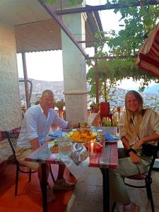 瓦迪穆薩的住宿－Petra downtown house，坐在餐桌旁吃饭的男人和女人