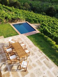 a patio with a table and chairs and a swimming pool at Quinta de Recião in Lamego