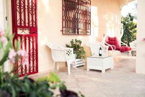 patio con sedie bianche e porta rossa di Casa in campagna ⋅ ForiMìa a San Vito dei Normanni