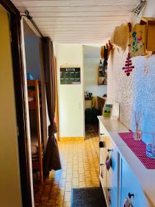 a kitchen with a white counter top and a room at Le SAPET in Ancelle