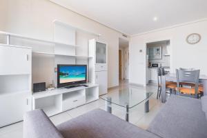 een woonkamer met een televisie en een tafel bij Gemelos 26 Resort Apartment 9-C Levante Beach in Benidorm