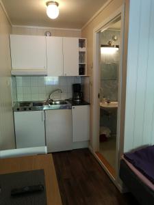 a small kitchen with white cabinets and a sink at Kvamsdal Pensjonat 1 in Eidfjord