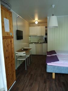 a room with a bed and a table and a kitchen at Kvamsdal Pensjonat 1 in Eidfjord