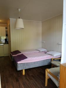 a room with two beds in a room with wooden floors at Kvamsdal Pensjonat 1 in Eidfjord