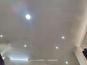 Cette chambre est dotée d'un plafond blanc avec un projecteur. dans l'établissement Fadhili House, à Naivasha