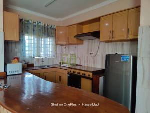 a kitchen with wooden cabinets and a stainless steel refrigerator at Fadhili House in Naivasha