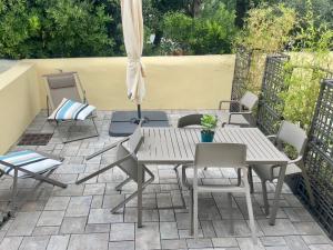 a patio with a table and chairs and an umbrella at Via Zug in Castiglioncello