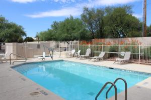 a swimming pool with chairs and a fence at Comfort Inn Green Valley I-19 in Green Valley