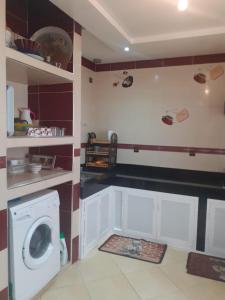 uma cozinha com uma máquina de lavar roupa num quarto em Beautiful apartment em Agadir