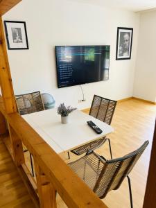 a dining room with a table and chairs and a tv at City Appartement Kirchheim in Kirchheim unter Teck