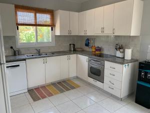 eine weiße Küche mit weißen Schränken und einem Waschbecken in der Unterkunft Holiday Home Emba in Emba