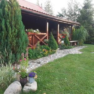 un jardín con una casa con flores y plantas en Domek w Kwiatach en Mrągowo