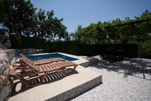een patio met 2 houten stoelen en een zwembad bij Villa Asmaaltı in Demre