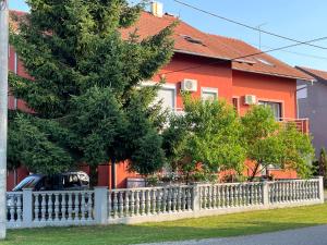 een wit hek voor een rood huis bij Apartment T&M Zagreb Airport in Velika Gorica