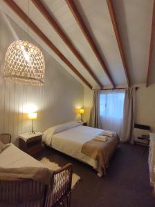 um quarto com 2 camas e um lustre em Los Calafates Hotel em Ushuaia