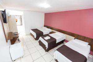 伊瓜蘇的住宿－A1 hotel，酒店客房设有两张床和红色的墙壁。