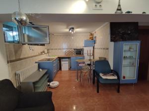 a small kitchen with blue cabinets and a table and chairs at Apartamento Acogedor in Cicero