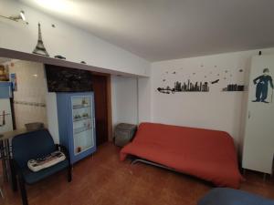 a bedroom with a red bed and a refrigerator at Apartamento Acogedor in Cicero