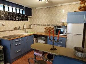 a kitchen with blue cabinets and a white refrigerator at Apartamento Acogedor in Cicero