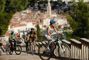 a group of people riding bikes on a bridge at Apartment for 6 people with parking near beach Trstenik in Split