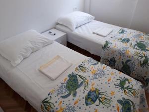 two beds sitting next to each other in a bedroom at Apartment for 6 people with parking near beach Trstenik in Split