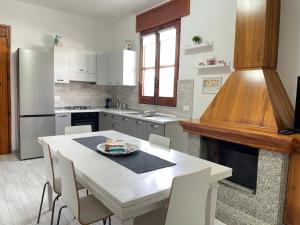 a kitchen with a table with chairs and a refrigerator at Villa Berenice in Pachino