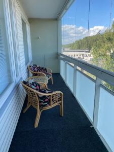 2 Stühle auf einem Balkon mit Fenstern in der Unterkunft kauppalankatu kolmio in Kouvola