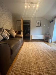 uma sala de estar com um sofá e um tapete em The Annexe em Winterbourne