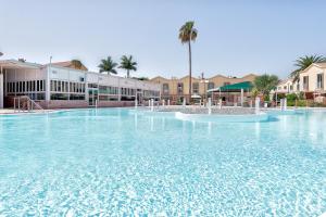 Una gran piscina de agua azul en un complejo turístico. en BUNGALOW en CAMPO INTERNACIONAL, en Maspalomas
