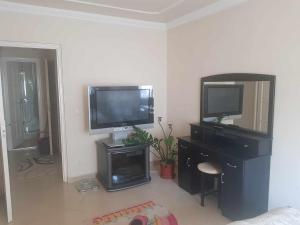 a living room with a television and a desk with a tv at Elaktra Apartman in Szolnok