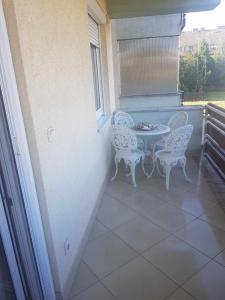 patio con mesa y sillas en el balcón en Elaktra Apartman en Szolnok