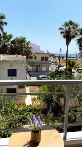 - un balcon avec un pot de fleurs sur une table dans l'établissement Sea Through Apartment Anavissos, à Anavyssos