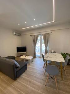 - un salon avec un canapé et une table dans l'établissement Sea Through Apartment Anavissos, à Anavyssos