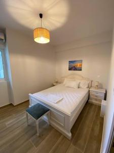 una camera con un grande letto bianco e una lampada di Sea Through Apartment Anavissos ad Anávissos